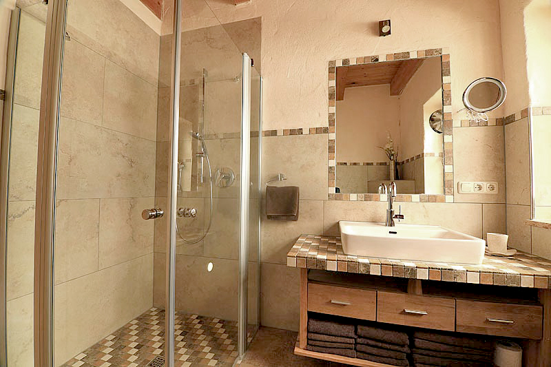 Badezimmer mit begehbarer Dusche, einem Waschbecken und umrahmten Spiegel