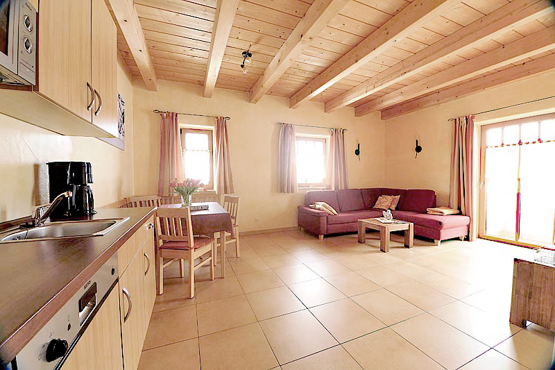 Sonnige Ferienwohnung mit Couch und Couchtisch, Fliesenboden und Holzdecke, sowie eine Küche