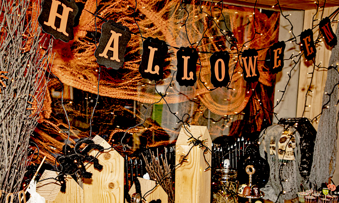 Halloweenparty mit Decoration aus Spinnen, Reisig, Holztürmen und mit einem Bufett