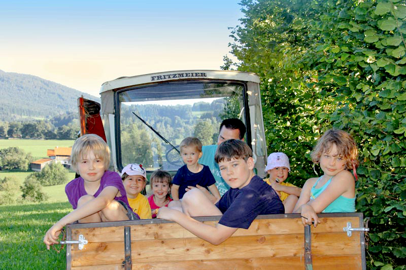 Viele Kinder auf dem Traktorauf einer Wiese