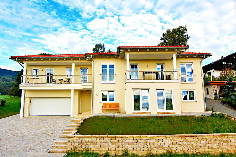 Toskana Haus mit blau weißen Himmel und Rasenfläche vor dem Haus