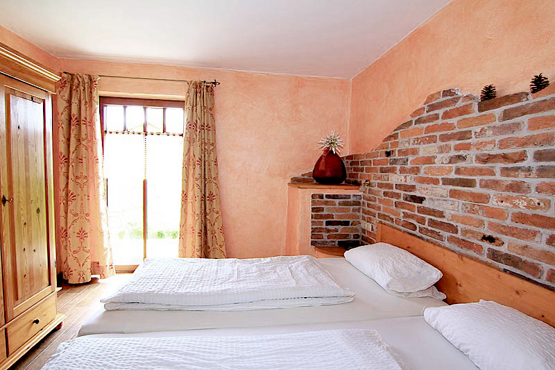 Schlafzimmer mit roter Wandfarbe, ein Doppelbett und ein Kleiderschrank